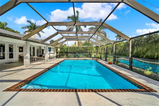 view of swimming pool with a patio area, french doors, and a lanai