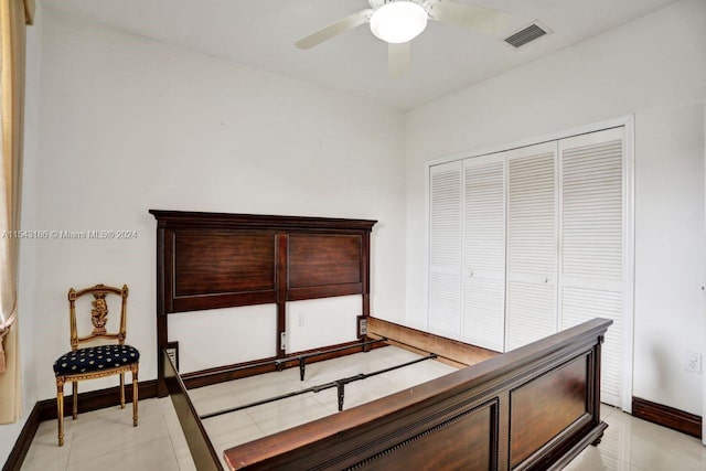 tiled bedroom featuring ceiling fan and a closet