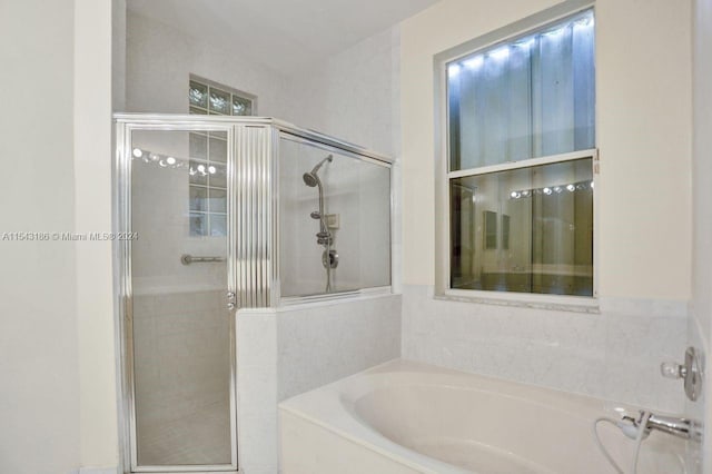 bathroom featuring shower with separate bathtub