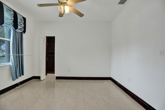 empty room featuring ceiling fan and light tile patterned flooring