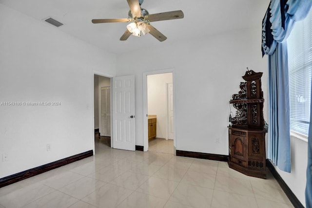 tiled bedroom with ceiling fan and ensuite bathroom