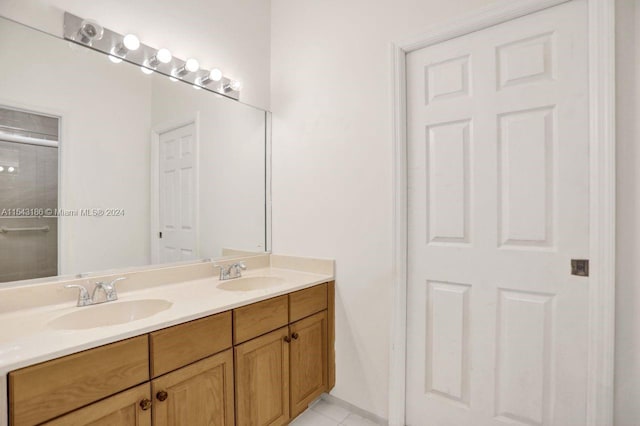 bathroom featuring a shower with door, tile patterned flooring, and vanity