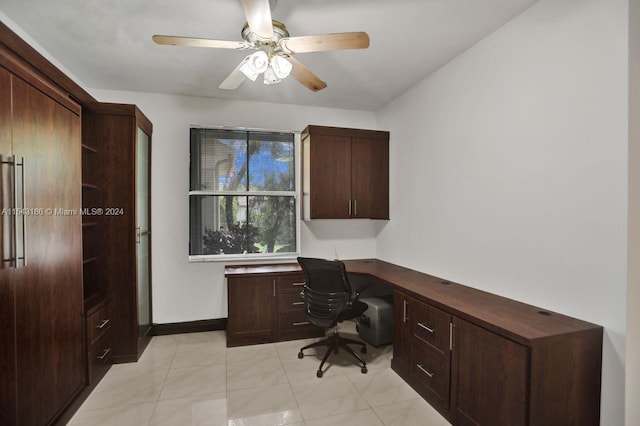 office space with ceiling fan, built in desk, and light tile patterned flooring