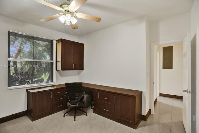 tiled office space featuring built in desk, ceiling fan, electric panel, and plenty of natural light