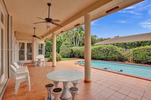 view of patio / terrace with ceiling fan, a fenced in pool, and french doors