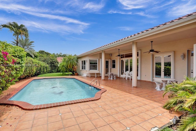 view of swimming pool with ceiling fan, a patio area, and french doors