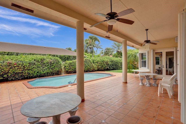 view of swimming pool with a patio, ceiling fan, and french doors