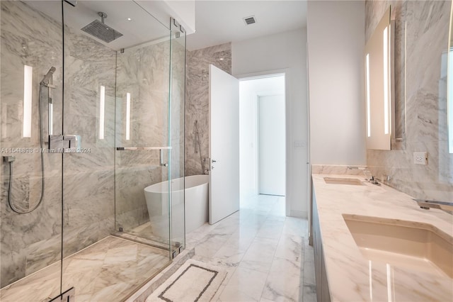 bathroom with dual sinks, separate shower and tub, tile floors, and tile walls