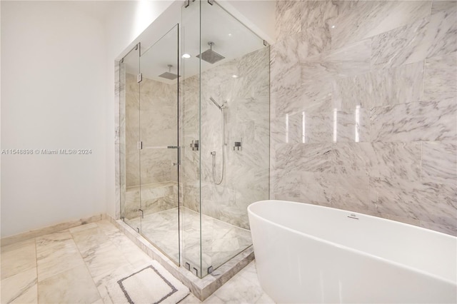 bathroom with tile flooring, separate shower and tub, and tile walls