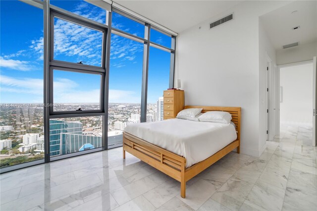 tiled bedroom with a wall of windows and multiple windows