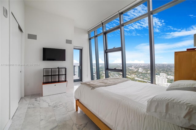 bedroom featuring expansive windows and light tile floors