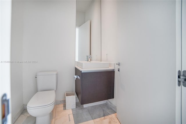 bathroom featuring tile flooring, toilet, and vanity