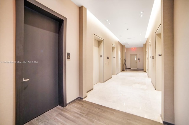 corridor featuring light hardwood / wood-style floors and elevator