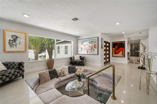 tiled living room featuring a textured ceiling