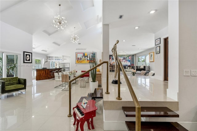 staircase featuring tile flooring, a chandelier, and a healthy amount of sunlight