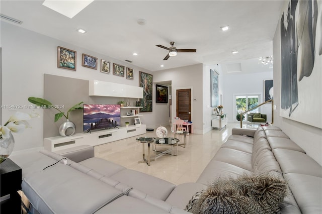 living room featuring ceiling fan with notable chandelier and tile flooring