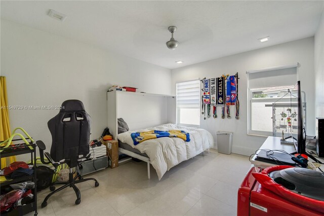 bedroom with ceiling fan and light tile floors