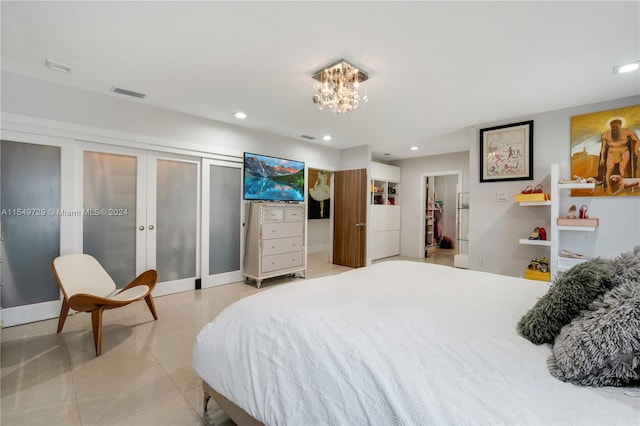 bedroom with french doors, a chandelier, and light tile floors