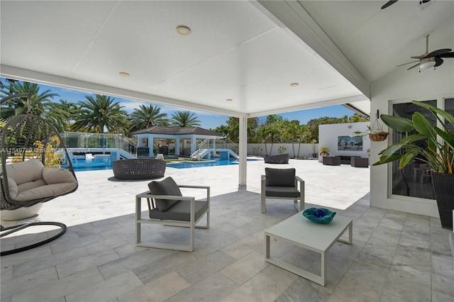 view of terrace with outdoor lounge area, ceiling fan, and a fenced in pool