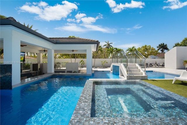 view of pool featuring a patio area, ceiling fan, and an in ground hot tub