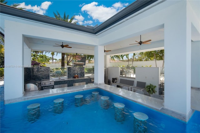 view of swimming pool with sink, ceiling fan, and an outdoor kitchen