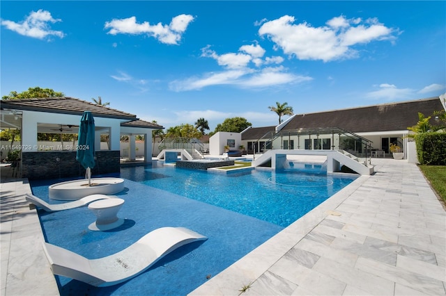 view of pool with ceiling fan, a jacuzzi, and a patio