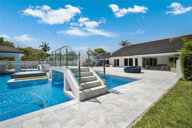 view of pool with a hot tub and a patio