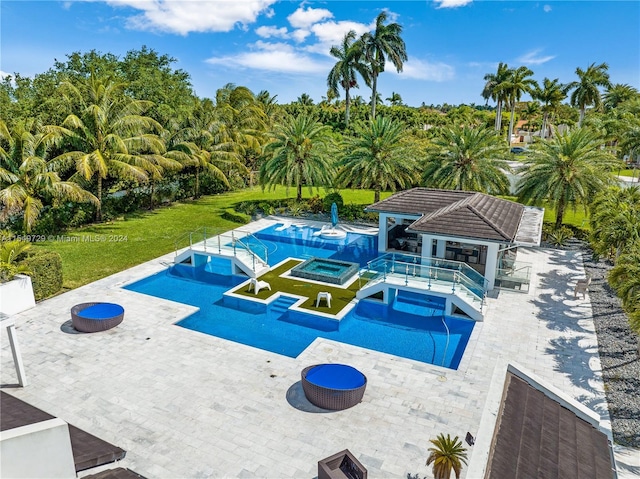 view of pool featuring a patio area, a yard, and an in ground hot tub