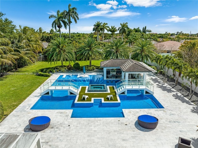 view of swimming pool with a patio, a yard, and an in ground hot tub