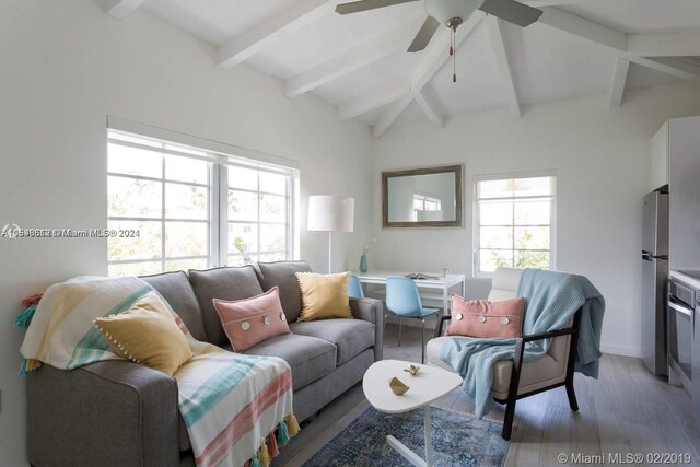 living room with ceiling fan, vaulted ceiling with beams, and hardwood / wood-style flooring