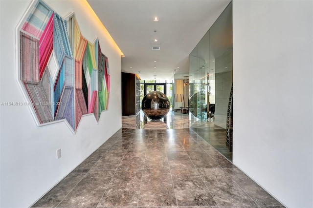 hall with dark tile flooring