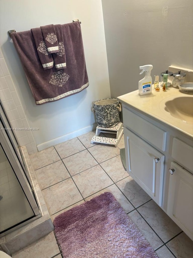 bathroom featuring vanity, a shower with door, and tile flooring