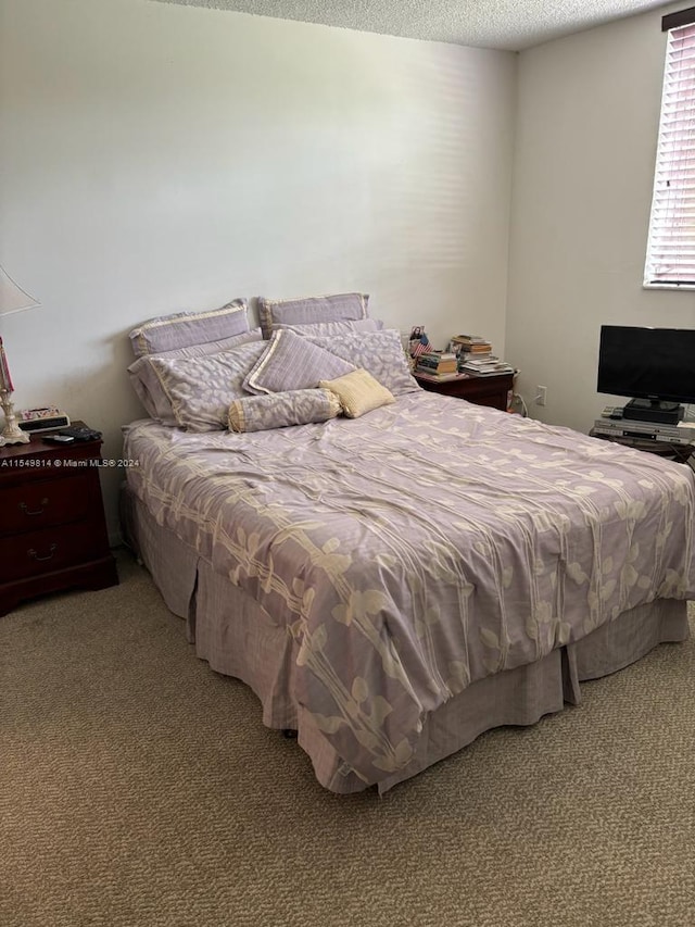 carpeted bedroom featuring a textured ceiling