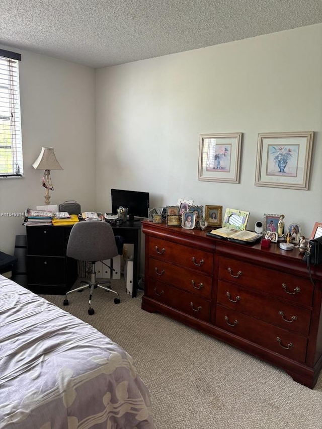 bedroom with light carpet and a textured ceiling