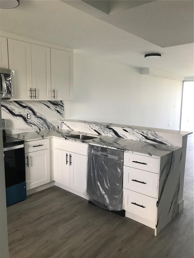 kitchen featuring tasteful backsplash, dark hardwood / wood-style flooring, white cabinets, and appliances with stainless steel finishes