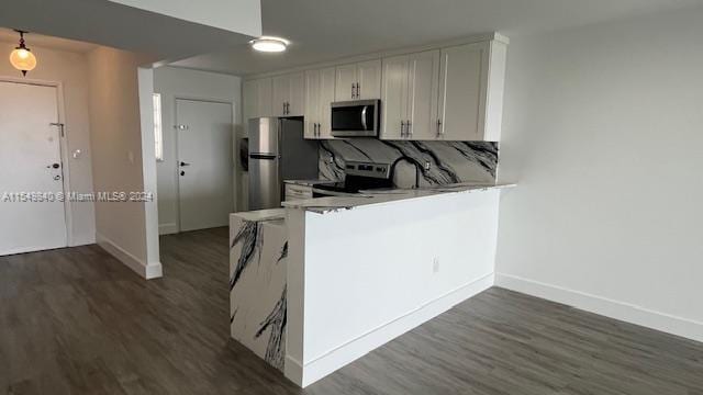 kitchen featuring dark hardwood / wood-style flooring, white cabinetry, stainless steel appliances, and tasteful backsplash