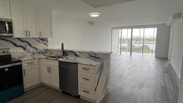 kitchen featuring white cabinetry, sink, light stone counters, and appliances with stainless steel finishes