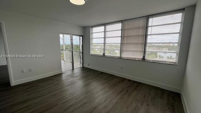 unfurnished room with dark hardwood / wood-style flooring