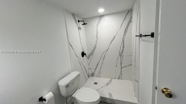 bathroom with toilet and tiled shower