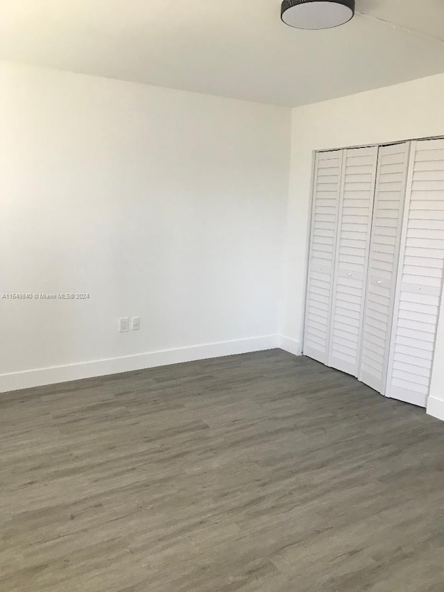 unfurnished bedroom featuring dark hardwood / wood-style flooring and a closet