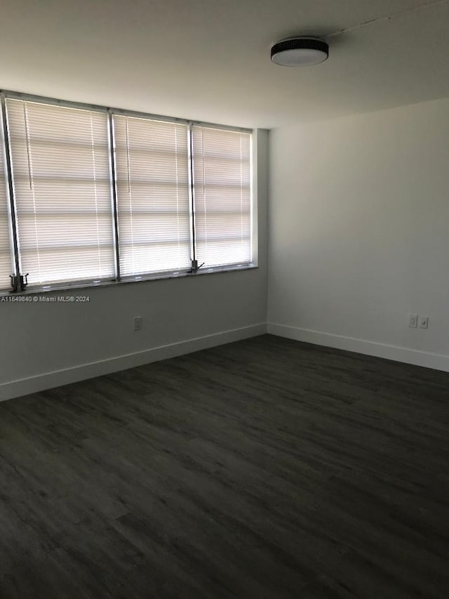 spare room with dark hardwood / wood-style flooring