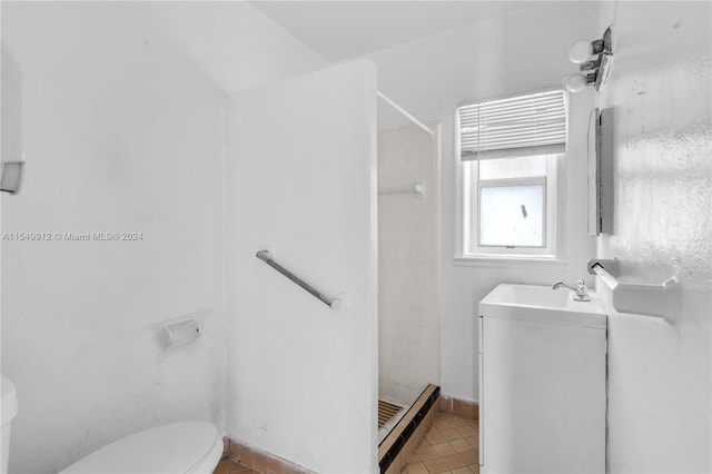 full bath featuring a stall shower, toilet, a baseboard radiator, tile patterned flooring, and vanity