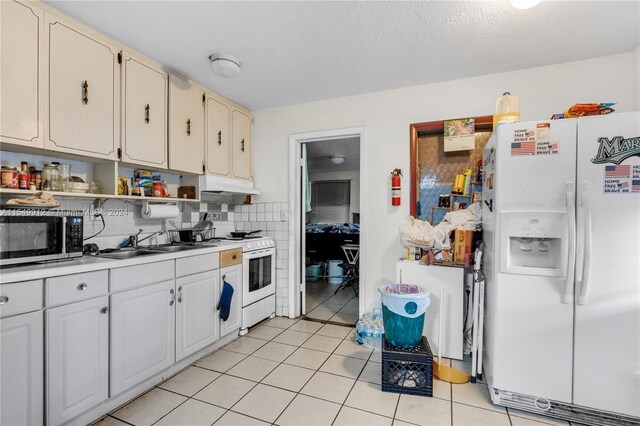 kitchen with backsplash, sink, white appliances, and light tile patterned floors