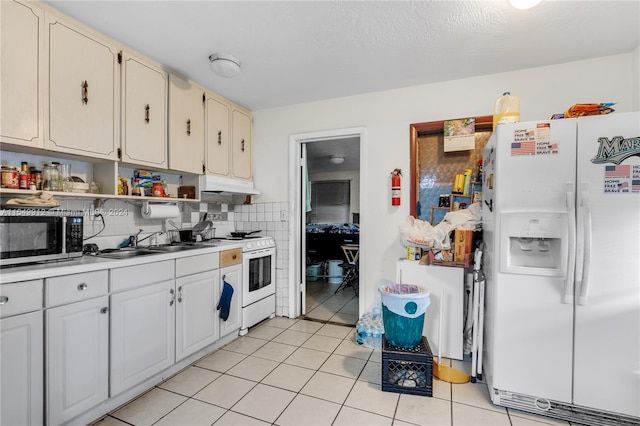 kitchen with light tile patterned floors, white appliances, a sink, and tasteful backsplash