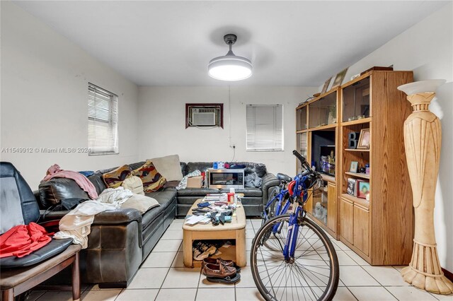 living room featuring an AC wall unit and light tile patterned floors