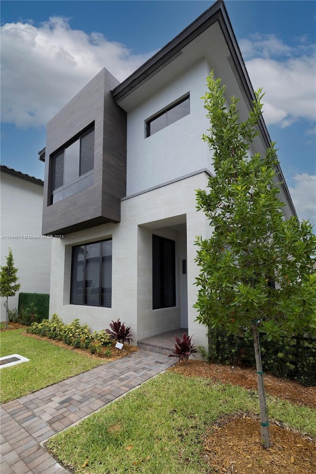 modern home featuring a front lawn