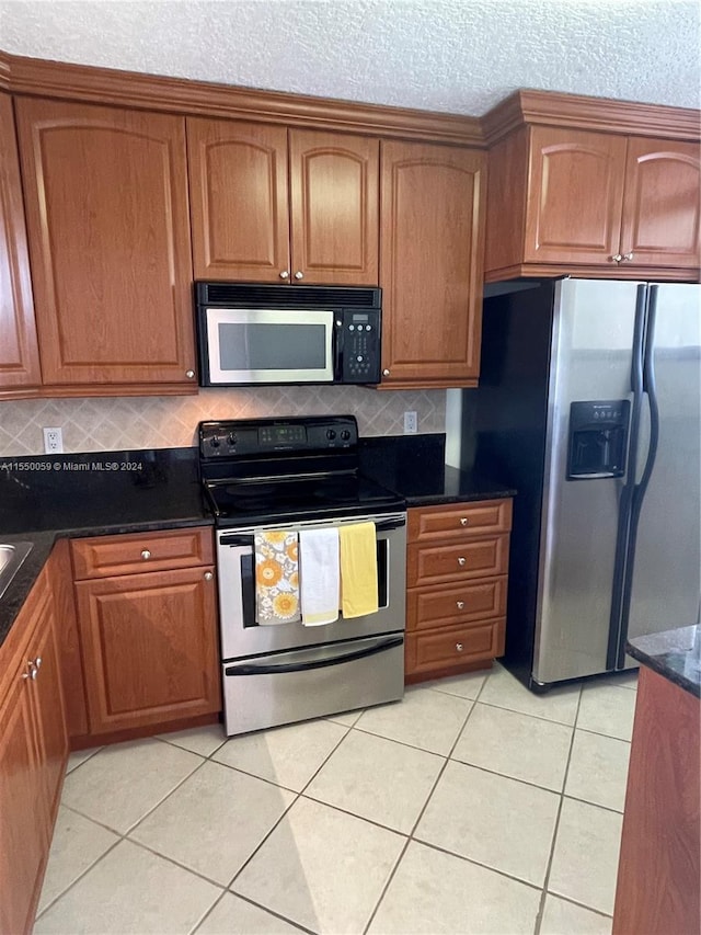 kitchen with light tile flooring, dark stone counters, stainless steel fridge with ice dispenser, backsplash, and electric range oven