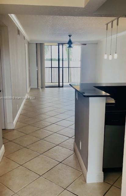 kitchen with floor to ceiling windows, crown molding, hanging light fixtures, light tile flooring, and a textured ceiling