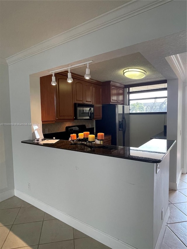 kitchen featuring kitchen peninsula, appliances with stainless steel finishes, light tile floors, tasteful backsplash, and pendant lighting