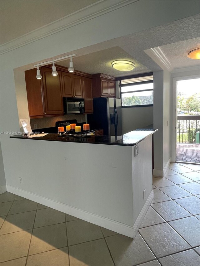 kitchen with ornamental molding, kitchen peninsula, light tile floors, and appliances with stainless steel finishes